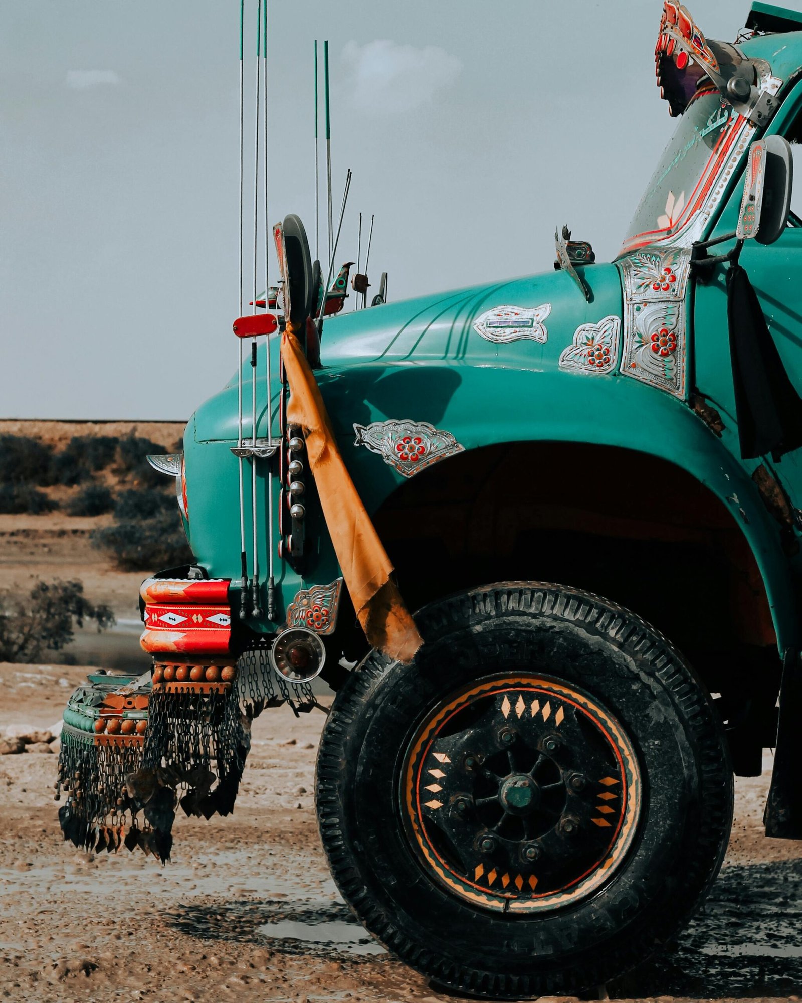 A vibrant custom-decorated truck showcasing traditional art in a desert setting.